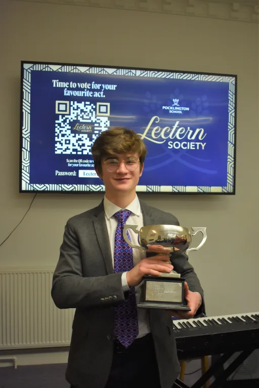 Winner of Lectern Society 2023, holding the winners cup