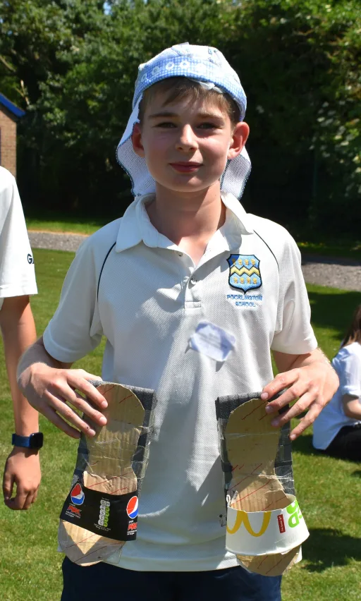 pupil holding shoes made from recycled rubbish