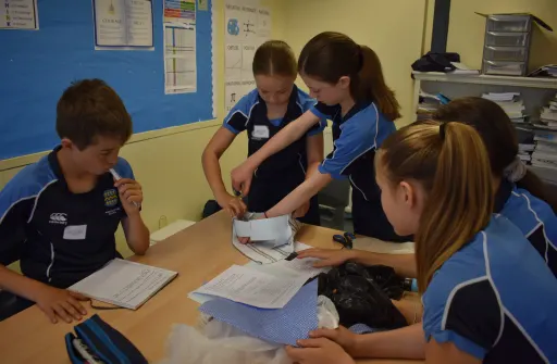 First Year pupils using recycled materials to make a hat in a classroom