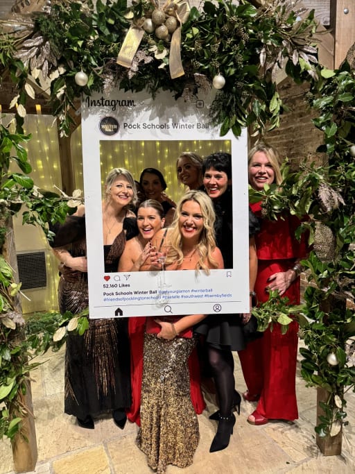 Members of the Friends wearing evening wear at the Pocklington School Ball, stood with instagram frame