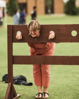 Pocklington School teacher wearing orange outfit, stood in the stocks at the PockFest event