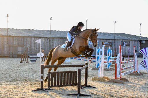 Rider and horse jumping over a jump in a show jumping arena at the Jumping with Style competition in Northallerton