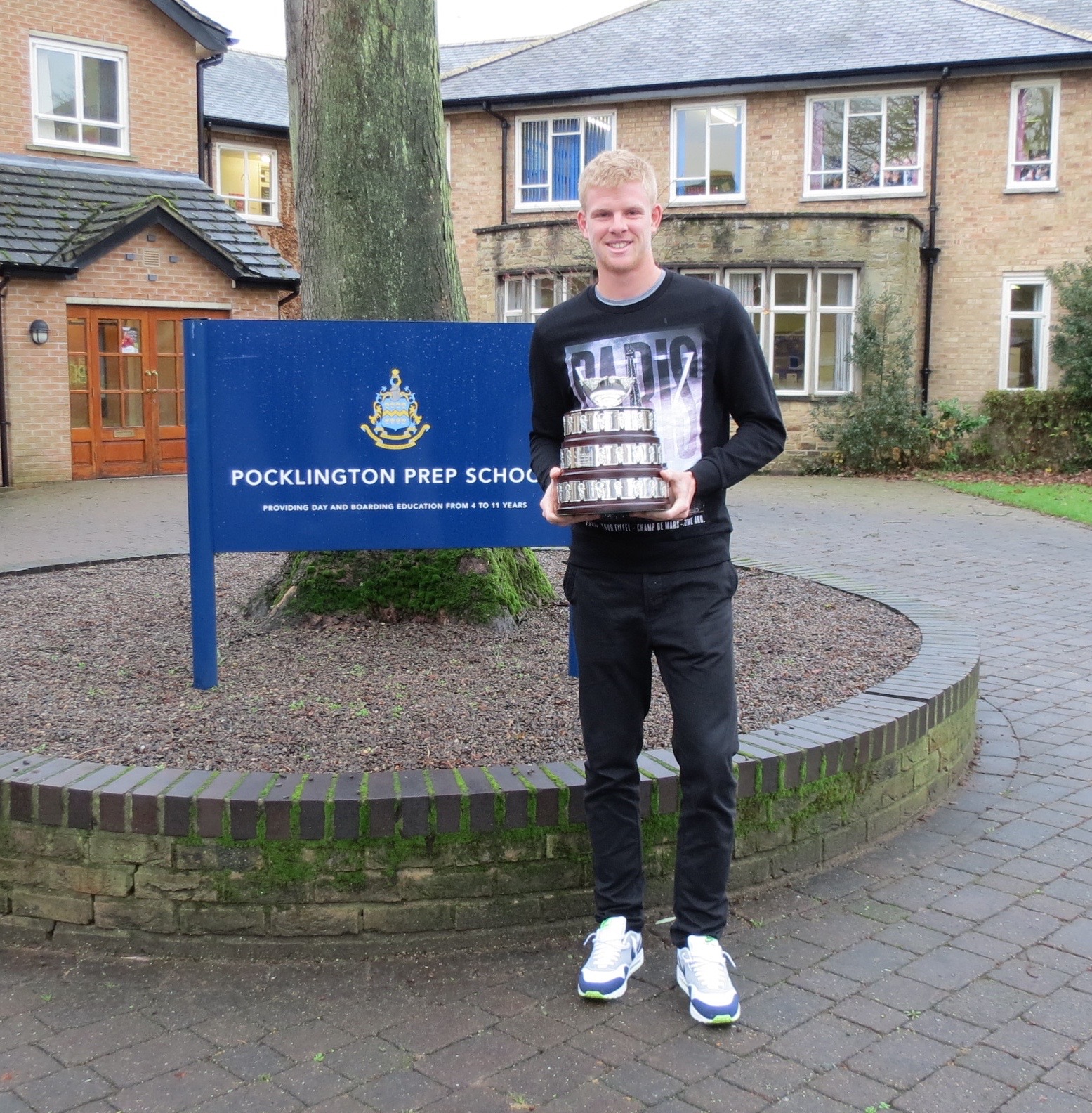 Kyle Edmund with a replica Davis Cup Trophy on a return visit to Pocklington Prep School