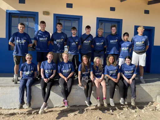 group of 16 teenagers in team uniform outside a building