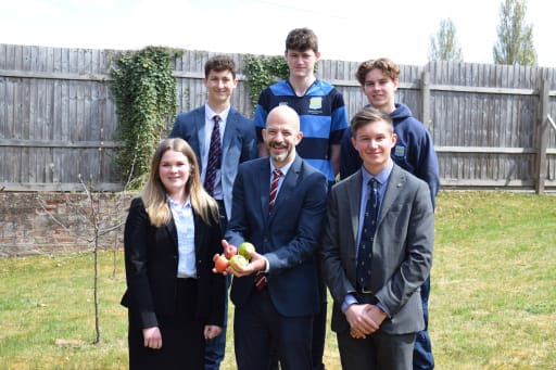 BTEC Pupils and Teacher at Pocklington School in garden with apple trees and apples.