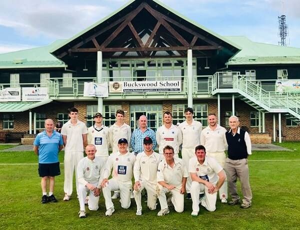 Pixies Cricket Team 2019 stood infront of a cricket pavilion on tour