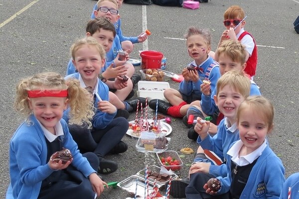 Prep School pupils sat in playground, sharing cakes as part of the tea party to celebrate the arrival of the royal baby.