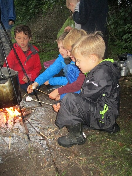 Pocklington Prep School boys gather round a fire to toast marshmellows