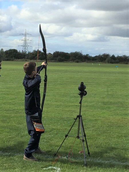 Pocklington School pupil shooting a bow and arrow in a Clout Archery Competition