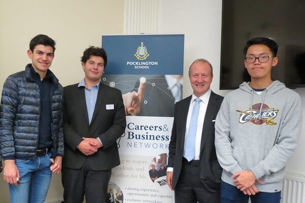 Three Pocklington School pupils stand with speaker in front of the Careers and Business Netowrk banner at a network event