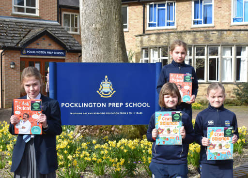 4 Pock Prep pupils hold their science book prize, standing outside Pocklington Prep School