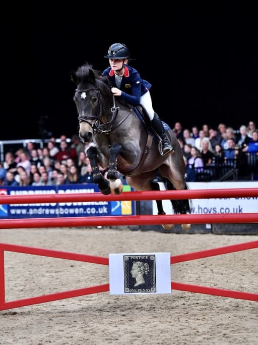 Pony and rider attempt show jump in arena at the Horse of the Year Show