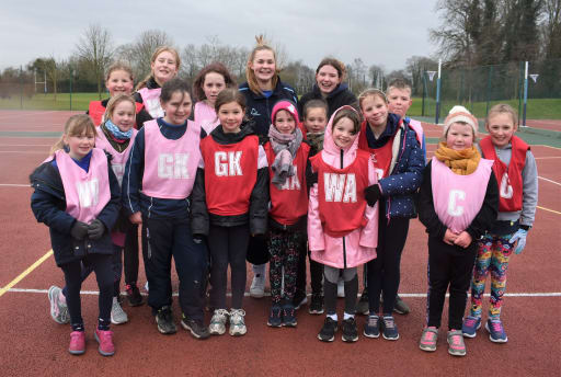 Primary school children wearing netball bibs at Pocklington School netball courts