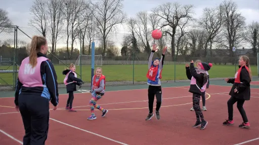 Primary school children playing netball, coached by Sixth Form pupils