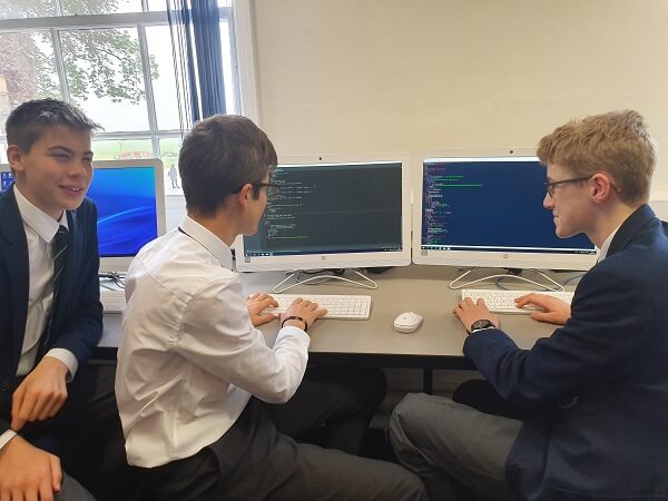 Three Pocklington School pupils working at computers in a classroom during the National Perse Coding Challenge