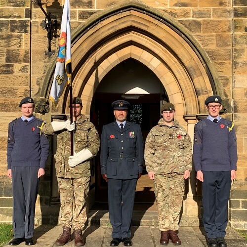 Four uniformed CCF cadets, one bearing flag, and officer stood outside St Catherine's Church, Barmby Moor