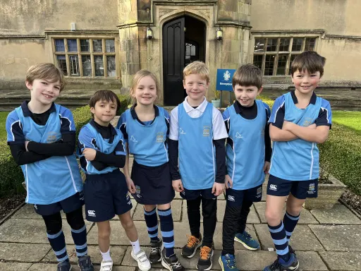  Pocklington Prep Cross Country team wearing sports kit stood in front of old school building