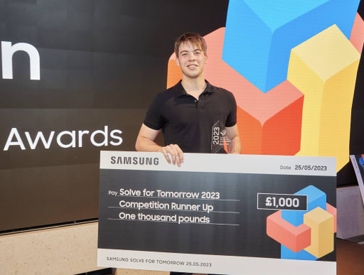 Teenager holding a large cheque at a prize presentation