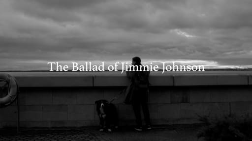 Man with dog, looking over a wall to the sea beyond