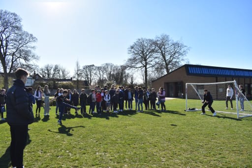 pupils watching penalty shoot-out on school field