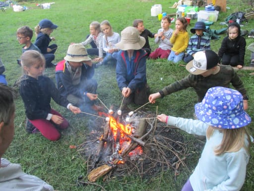 children toasting marshmallows over a camp fire on Pocklington School field