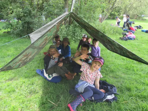 children sat in a survival shelter they made