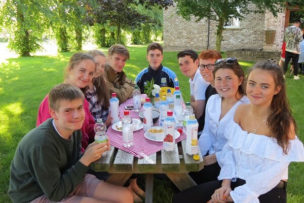 Boarding pupils sat at picnic table in grounds of boarding house