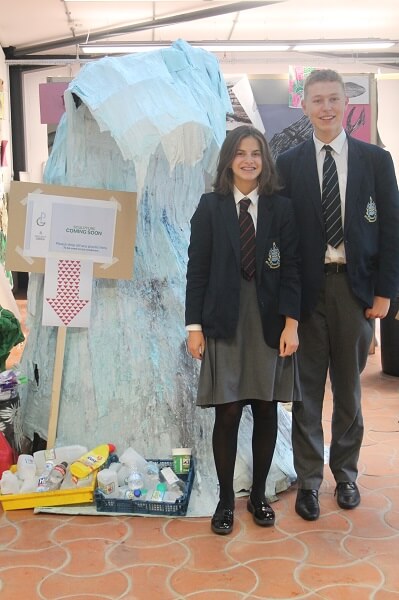 two pupils stood next to their sculpture of a living wave to show where discarded plastic ends up