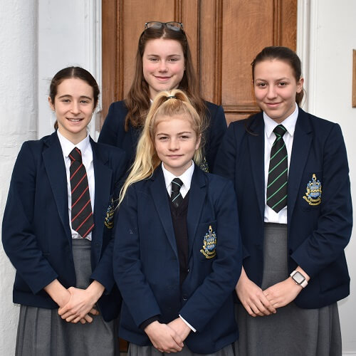 Members of the Intermediate Girls Cross Country team stood in uniform at the front of Pocklington School