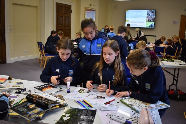 Pocklington School pupils sat at a table making a poster