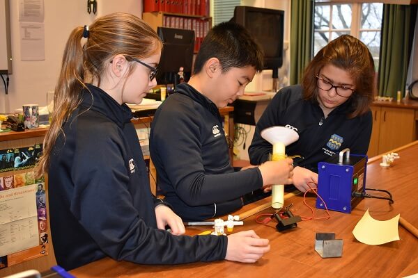 Three pupils in a school physics lab making speakers