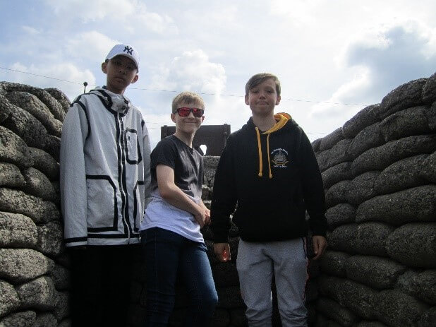 three boys stood in stone trench at Vimy Ridge, France