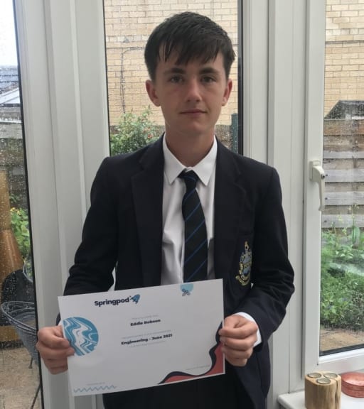 Boy in school uniform holding certificate of acheivement awarded by Springpod