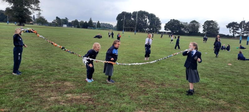 Four school girls skipping on the school field at Pocklington Prep School